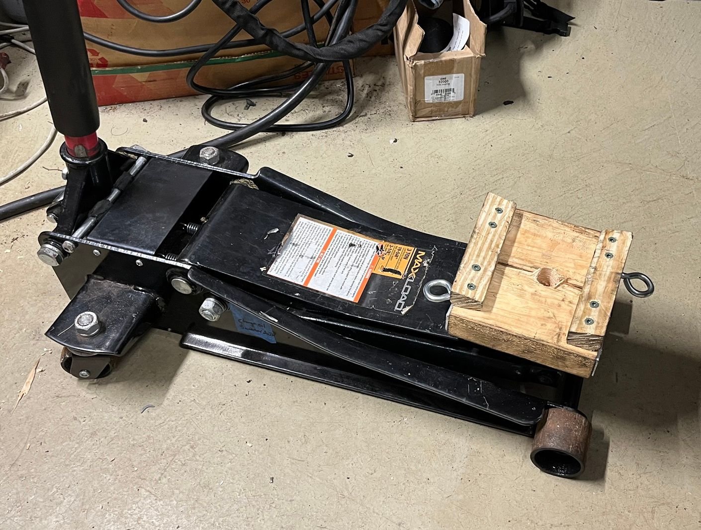 Wood carrier bolted to jack.  Eyes for strap.