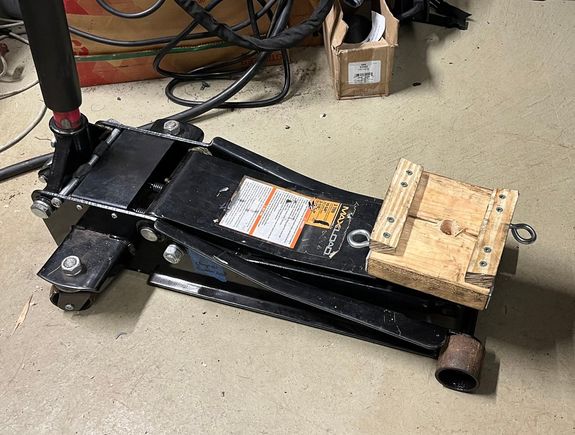 Wood carrier bolted to jack.  Eyes for strap.