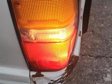 Passenger side with tail light bleeding through into white reverse reflector