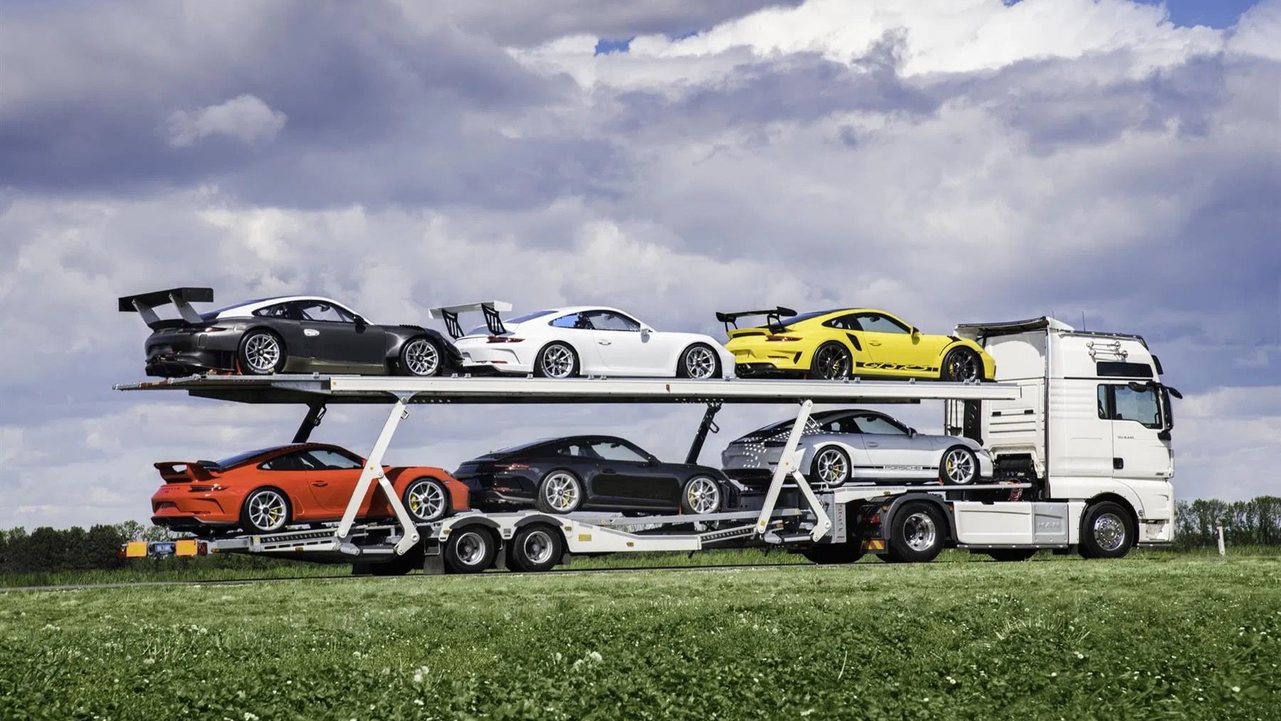 Porsche collection with transporter truck (photo via PistonHeads)